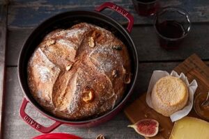 Staub Round Cocotte 24 cm Cherry Red in a kitchen setting, showcasing its elegant design and versatility.